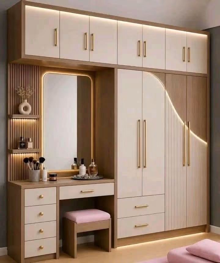 Floor-to-ceiling wardrobe with a curved fluted panel, gold handles, an integrated backlit dressing mirror, drawers and loft storage
